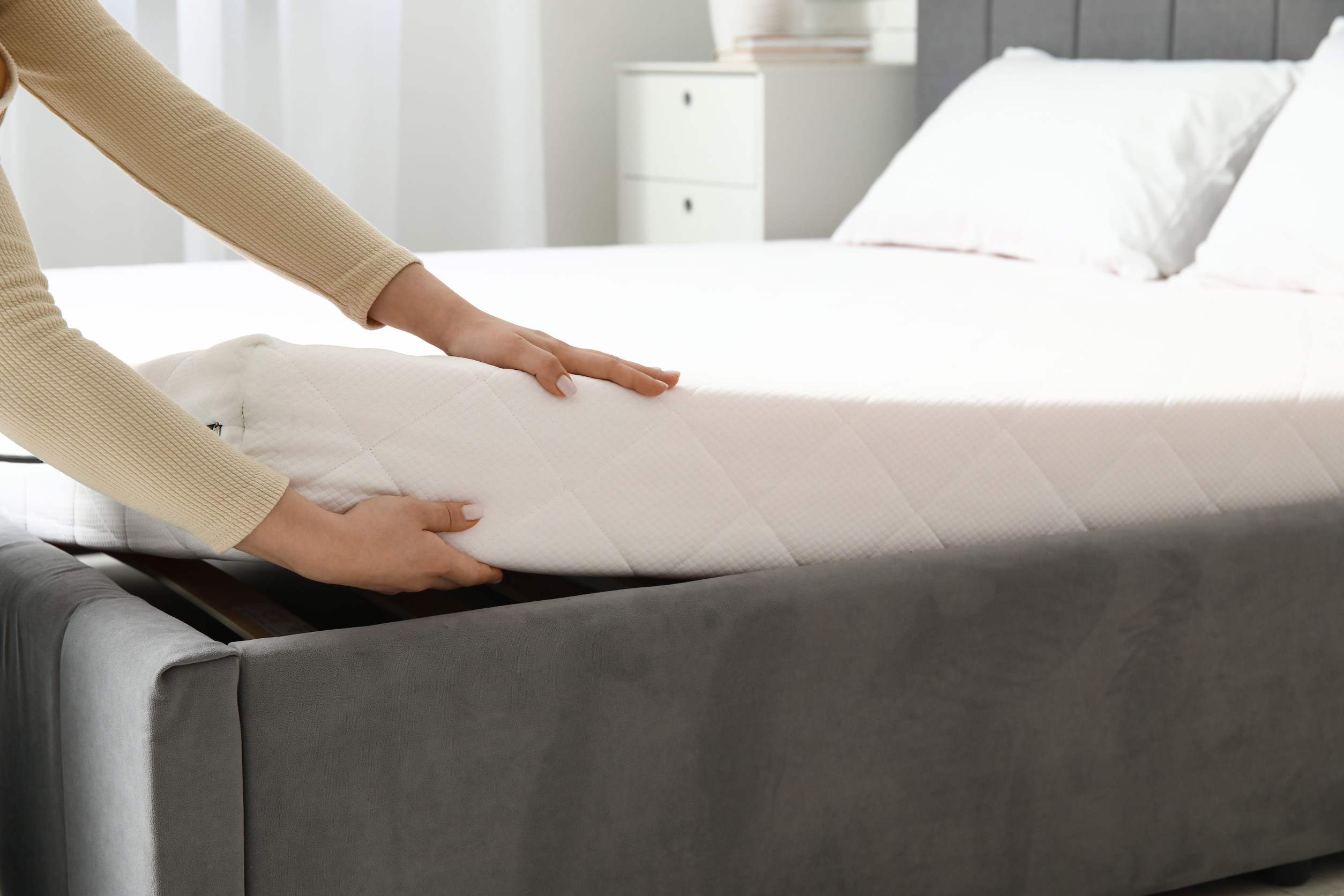 Personne installant un matelas dans une chambre
