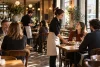 Équipe de salle accueillant des clients dans un bistrot français chaleureux