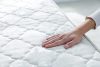 Main testant le confort d’un matelas naturel
